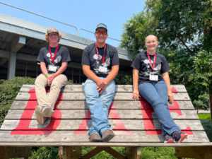 4-Hers at NCSU pose for a picture on a tall bench