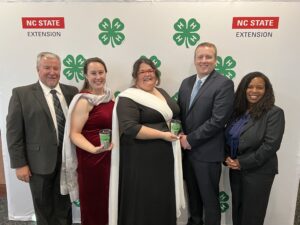 Image of Ashley and Kait receiving an award for outreach efforts in 4-H